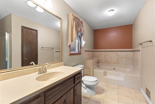 bathroom featuring a bathing tub, vanity, toilet, tile patterned floors, and a textured ceiling