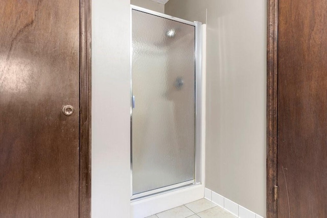 bathroom with tile patterned floors and a shower with door