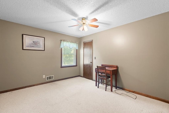 carpeted spare room featuring ceiling fan and a textured ceiling