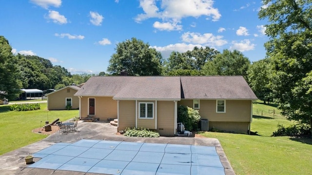 back of property with a yard and a patio area