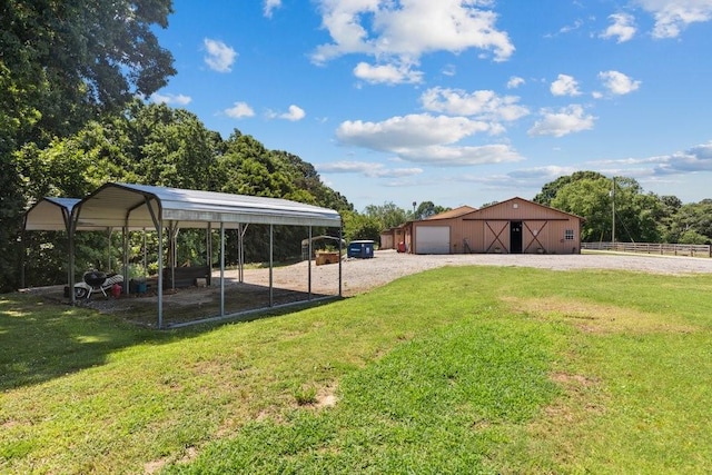 view of yard featuring a garage, an outdoor structure, and a carport