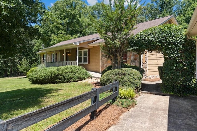 ranch-style home with a front yard and covered porch