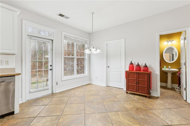 dining room featuring baseboards, light tile patterned flooring, visible vents, and a notable chandelier