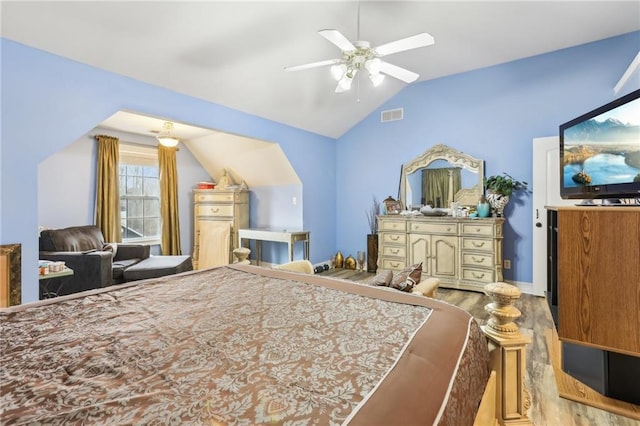 bedroom featuring ceiling fan, visible vents, vaulted ceiling, and wood finished floors