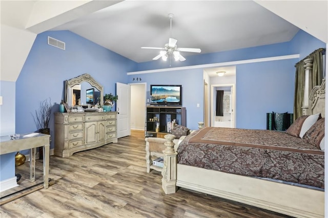 bedroom with visible vents, connected bathroom, vaulted ceiling, ceiling fan, and wood finished floors