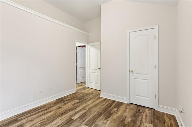 unfurnished bedroom featuring dark wood finished floors and baseboards