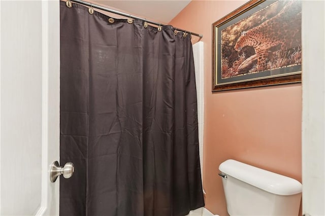 bathroom with curtained shower and toilet