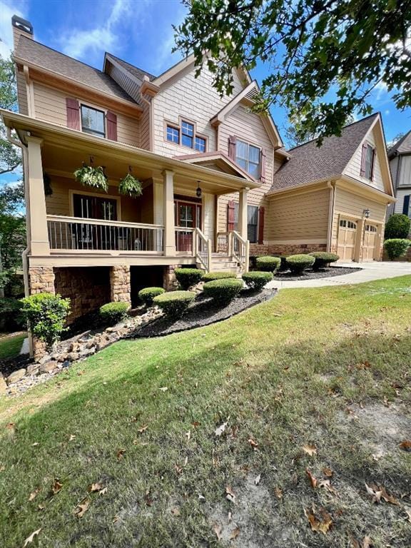 craftsman-style home featuring covered porch, a garage, and a front lawn