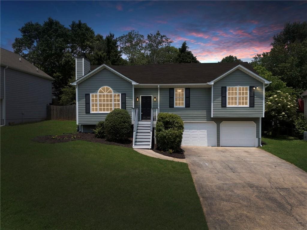 4255 Brandy Ann Dr, Acworth, GA 30101 - view of front facade with a garage, driveway, a front lawn, and a chimney