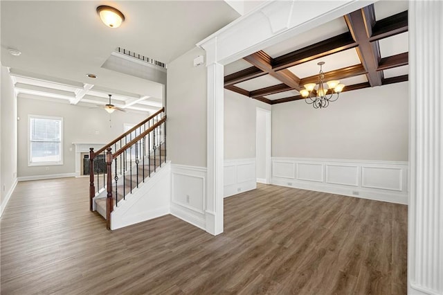 stairs featuring coffered ceiling, hardwood / wood-style floors, beam ceiling, and ceiling fan with notable chandelier