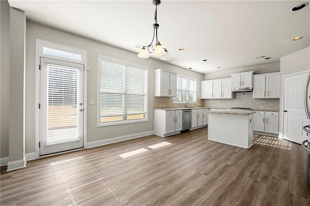 kitchen with white cabinetry, pendant lighting, tasteful backsplash, and a kitchen island