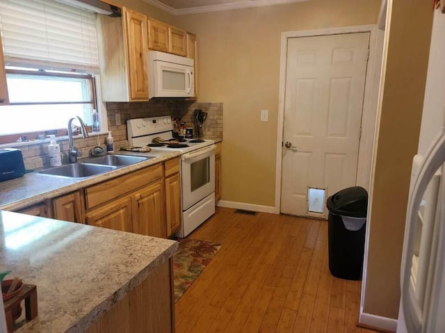 kitchen with sink, decorative backsplash, white appliances, crown molding, and light wood-type flooring