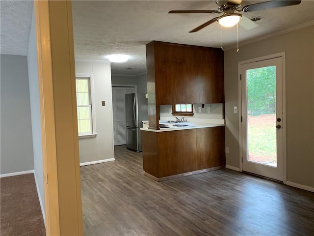 499 Oak Way, Lawrenceville, GA 30046 - kitchen with freestanding refrigerator, a peninsula, ornamental molding, a ceiling fan, and light countertops