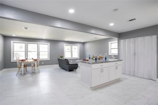 10664 Sandpiper Rd, Jonesboro, GA 30238 - kitchen featuring open floor plan, light marble finish floors, light stone counters, white cabinetry, and recessed lighting