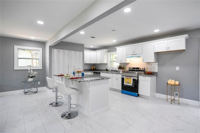 10664 Sandpiper Rd, Jonesboro, GA 30238 - kitchen with stainless steel appliances, light marble finish floors, baseboards, a breakfast bar, and white cabinets