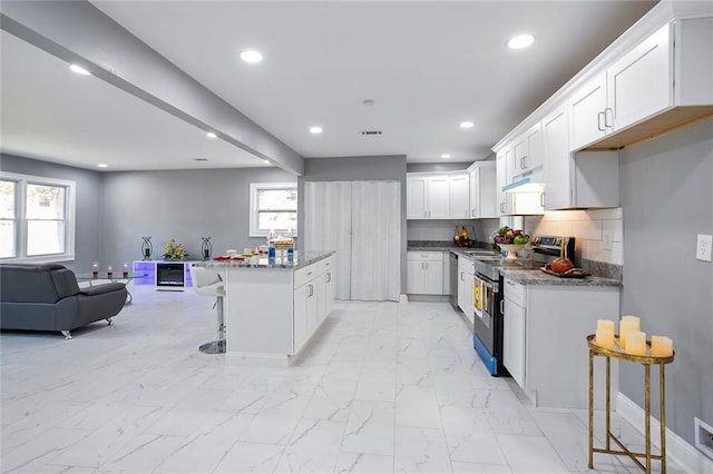 10664 Sandpiper Rd, Jonesboro, GA 30238 - kitchen featuring stainless steel appliances, open floor plan, a kitchen breakfast bar, recessed lighting, and light marble finish floors