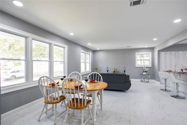 10664 Sandpiper Rd, Jonesboro, GA 30238 - dining room featuring healthy amount of natural light, recessed lighting, light marble finish floors, and baseboards