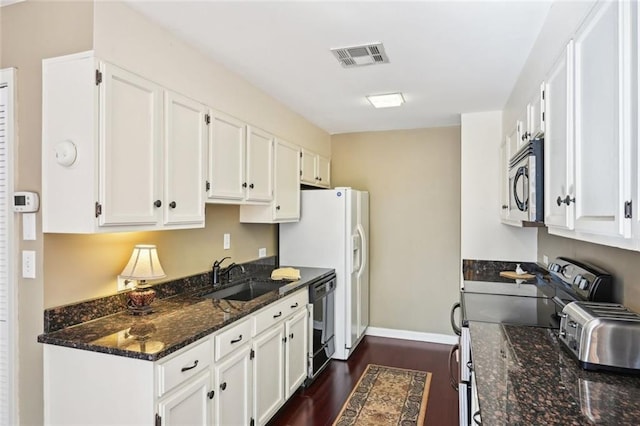 145 15th St NE Unit 204, Atlanta, GA 30309 - kitchen with a sink, stainless steel appliances, visible vents, dark wood finished floors, and white cabinetry