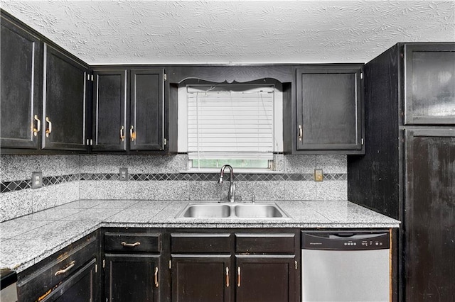 1822 Oriole Trl, Lithia Springs, GA 30122 - kitchen featuring stainless steel dishwasher, a sink, decorative backsplash, dark cabinets, and a textured ceiling