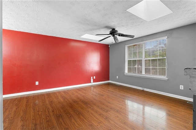 1822 Oriole Trl, Lithia Springs, GA 30122 - spare room with a skylight, a textured ceiling, a ceiling fan, wood finished floors, and baseboards