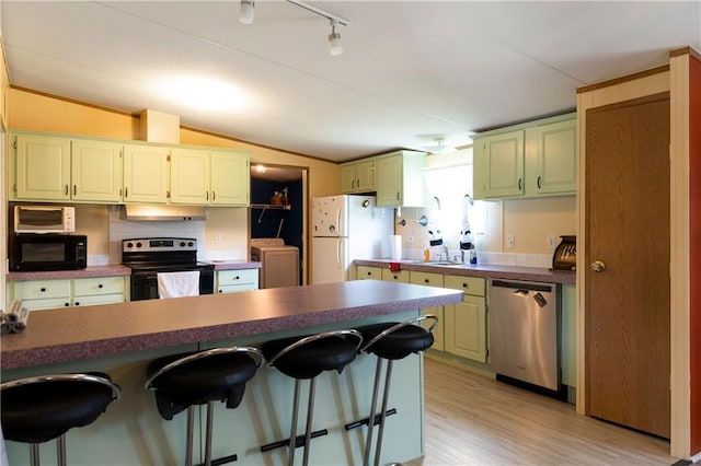 518 W Nance Springs Rd, Resaca, GA 30735 - kitchen featuring stainless steel appliances, under cabinet range hood, a kitchen breakfast bar, lofted ceiling, and light wood-type flooring