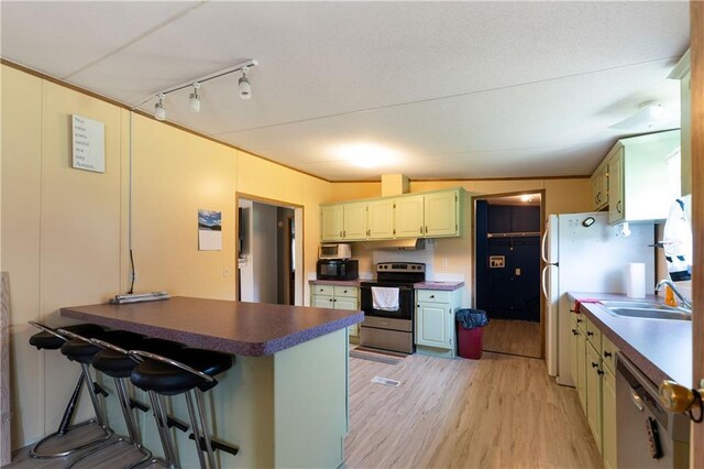 518 W Nance Springs Rd, Resaca, GA 30735 - kitchen with appliances with stainless steel finishes, a peninsula, light wood-style flooring, a kitchen breakfast bar, and rail lighting