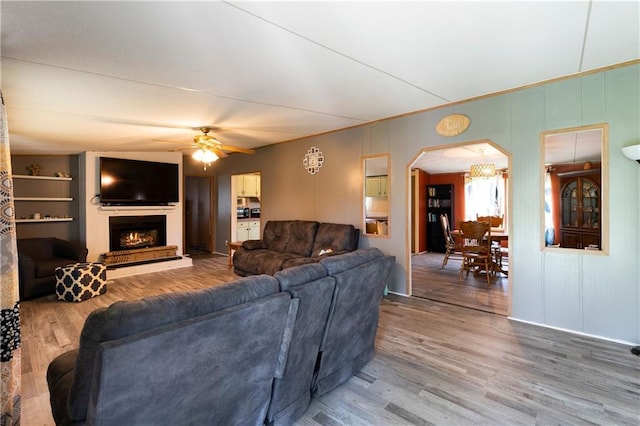 518 W Nance Springs Rd, Resaca, GA 30735 - living area with wood finished floors, a ceiling fan, arched walkways, and a lit fireplace