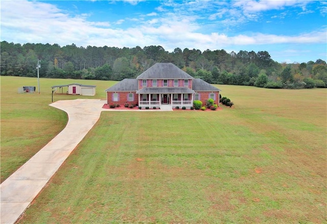 view of front of house with covered porch, a view of trees, and a front lawn