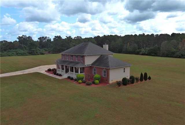 view of front of property featuring crawl space, a forest view, a porch, and a front lawn