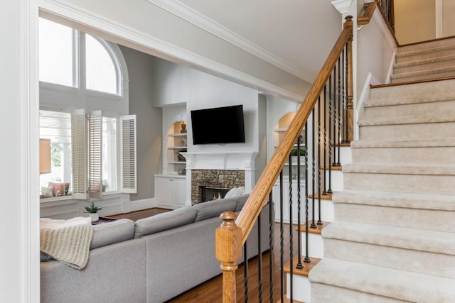 living area featuring plenty of natural light, ornamental molding, a fireplace, and wood finished floors