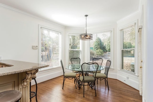 dining room featuring baseboards, an inviting chandelier, wood finished floors, and crown molding