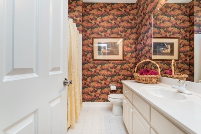 full bathroom with toilet, vanity, tile patterned flooring, baseboards, and wallpapered walls