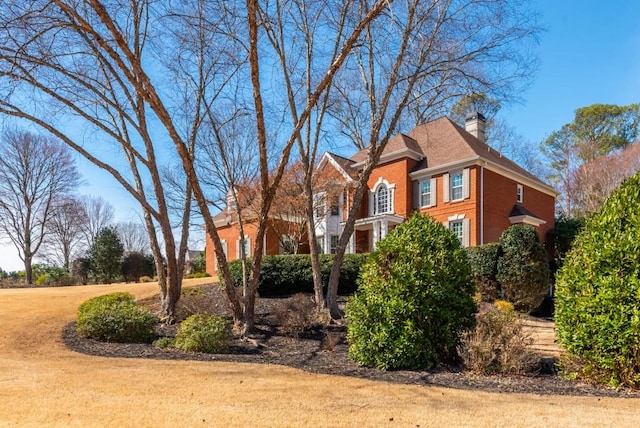 view of side of property with brick siding and a chimney