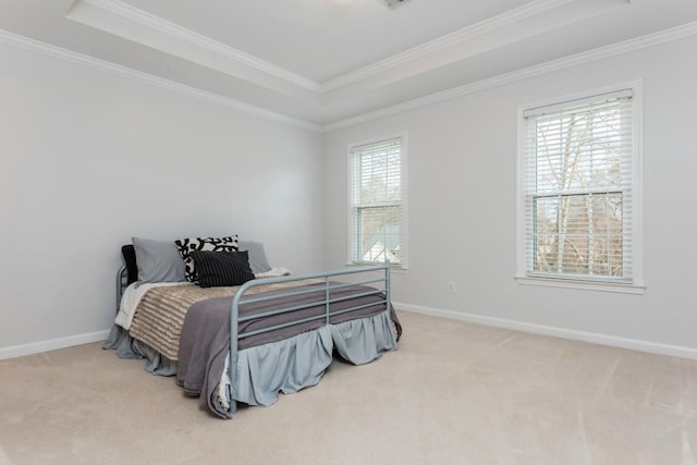 bedroom featuring crown molding, a tray ceiling, carpet flooring, and baseboards