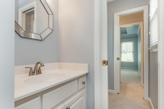 bathroom with crown molding, vanity, and baseboards