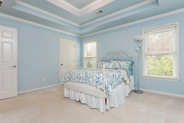 carpeted bedroom featuring visible vents, a tray ceiling, and ornamental molding