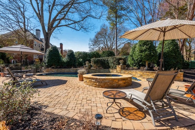 view of patio / terrace with an in ground hot tub