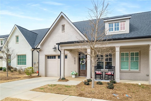 view of front of house with a porch, concrete driveway, roof with shingles, and a garage