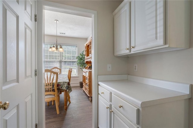 4321 Sugar Maple Chase NW, Acworth, GA 30101 - kitchen with dark wood-type flooring, a textured ceiling, light countertops, a chandelier, and white cabinetry