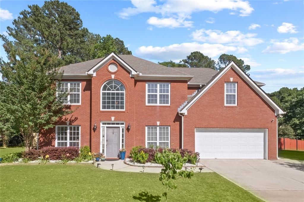 colonial house featuring a garage and a front yard