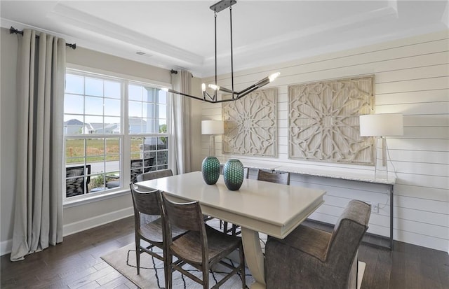 dining space featuring a tray ceiling, dark wood-type flooring, and a chandelier