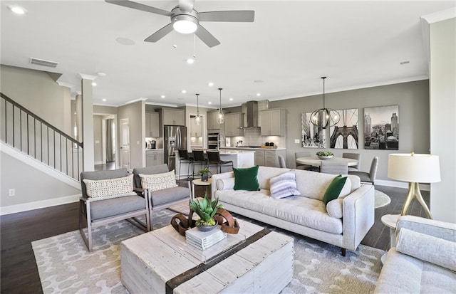 living area with visible vents, stairs, baseboards, and wood finished floors