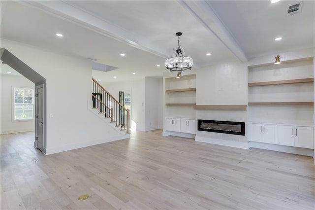 unfurnished living room with a notable chandelier, light hardwood / wood-style floors, built in features, and beam ceiling