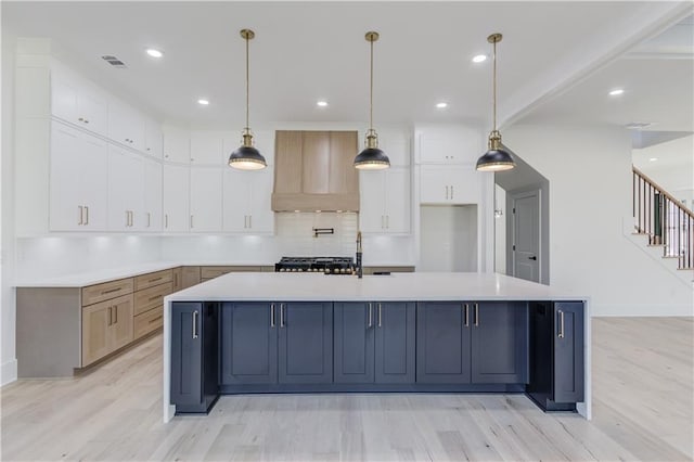 kitchen featuring a large island, light wood-type flooring, and decorative light fixtures