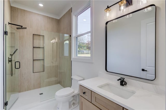 bathroom with vanity, toilet, ornamental molding, and walk in shower