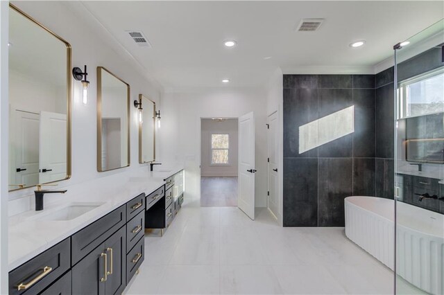 bathroom featuring a wealth of natural light, tile patterned flooring, vanity, and a bath