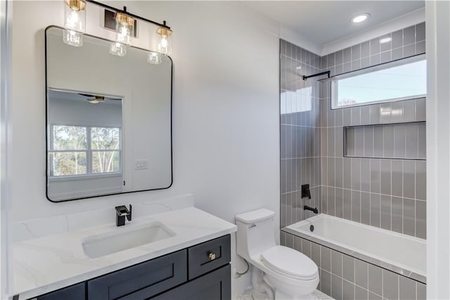 full bathroom with vanity, toilet, a wealth of natural light, and tiled shower / bath combo