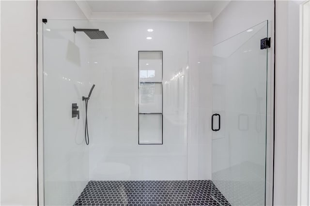 bathroom featuring a shower with door and crown molding