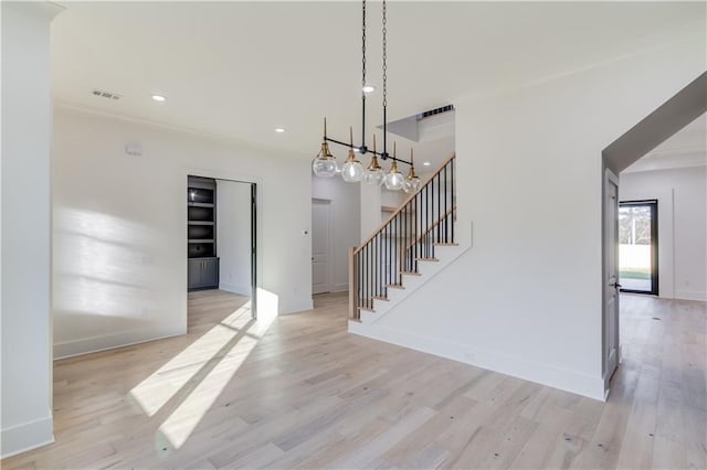 interior space with a notable chandelier and light wood-type flooring