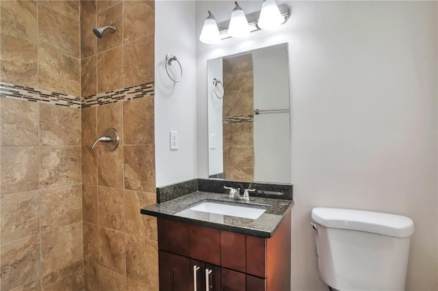 full bath featuring a tile shower, toilet, and vanity